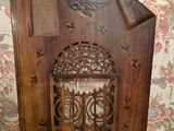 a wooden door with a bird on it in front of a floral wall
