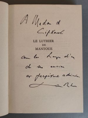 un gros plan d'un livre sur lequel on voit une écriture manuscrite, posé sur une table
