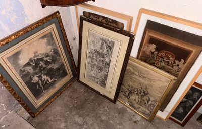 de nombreux tableaux encadrés posés par terre à côté d'une horloge