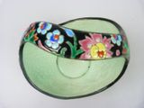 a black and green bowl with a flower design on it