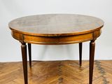 an oval dining table with a wooden top on a parquet floor