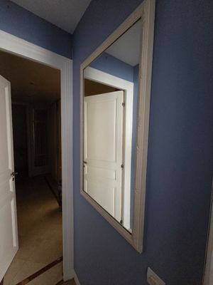 un miroir accroché au mur dans le couloir d'une maison