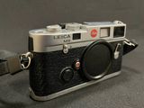 a black and silver camera with a strap around it