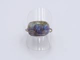 an image of a glass ring with a blue and purple stone in it