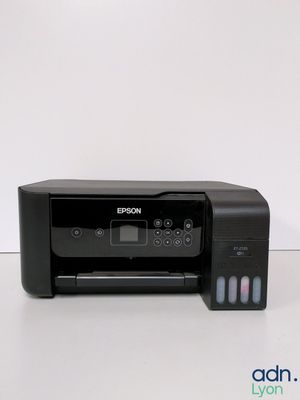 a black printer sitting on top of a table next to a white wall