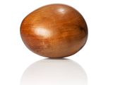 a wooden egg that is sitting on a white surface
