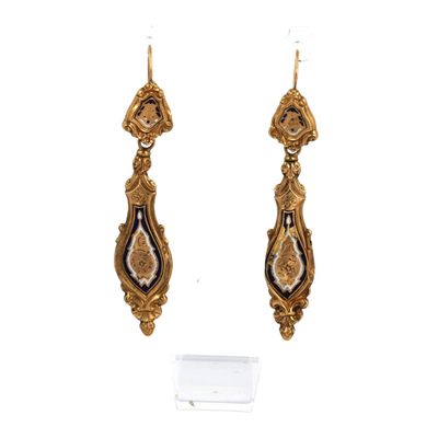 une paire de boucles d'oreilles en or ornées de motifs noirs et blancs