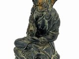 statue of a person sitting on a rock on a white background