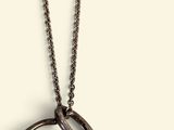 un gros plan d'un collier dont la chaîne présente un motif incurvé