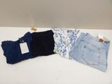 three pairs of jeans are sitting on a table next to each other