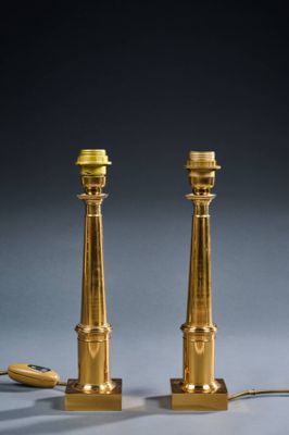 a pair of brass candles on a table next to a computer mouse