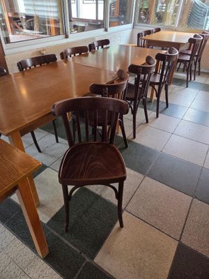 des tables et des chaises dans un restaurant doté de grandes baies vitrées et d'un sol à carreaux