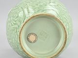 green vase with a gold rim on a white background