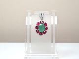 un gros plan sur un collier orné d'une pierre verte et rouge