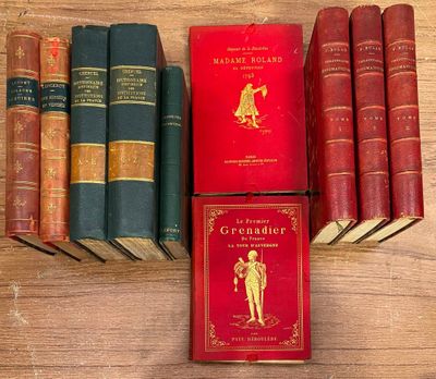 plusieurs vieux livres posés sur une table en bois, avec une couverture rouge