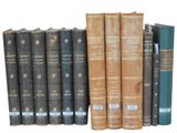 several old books are lined up on a shelf next to each other