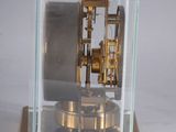 a glass case with a gold clock inside of it