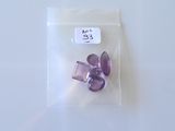 un petit sachet de perles violettes posé sur une table blanche