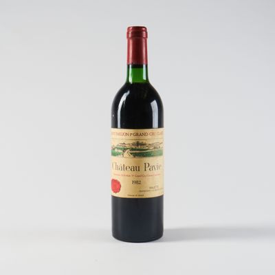 une bouteille de vin rouge posée sur une table blanche