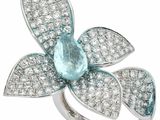 un gros plan d'une bague ornée d'une pierre couleur aqua en forme de fleur, entourée de diamants blancs