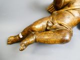 a gold statue of a baby laying on its back