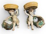 deux figurines d'anges portant des paniers sur la tête