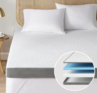 un gros plan d'un matelas posé sur un lit, avec des oreillers
