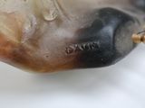 a close up of a sculpture of a fish on a white surface