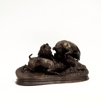 une statue en bronze représentant un lion et une lionne sur un rocher