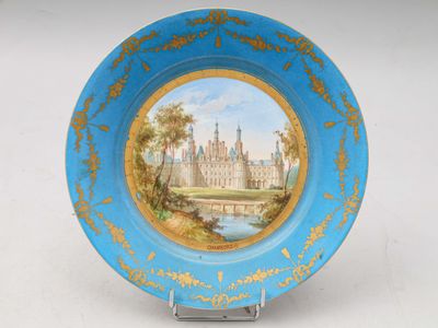 une assiette bleue sur laquelle est représenté un château