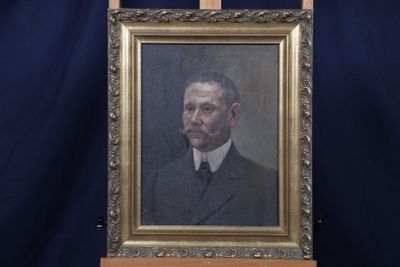 portrait d'un homme en costume-cravate dans un cadre doré