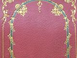 an old red book with gold trim and a gold border