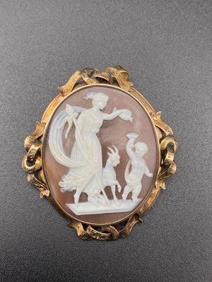 a white and brown cameo broochle with a woman and child