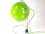 a green lamp that is on top of a metal stand