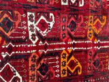 an image of a red and black rug on a gray floor