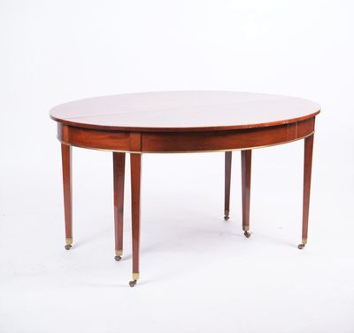 une table de salle à manger ovale avec quatre pieds et un plateau en bois