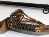 a close up of a sword on a white surface