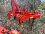a red machine that is sitting in the middle of a field