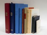 plusieurs livres sont alignés sur une surface blanche