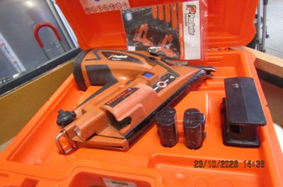 une boîte orange contenant une agrafeuse et d'autres outils