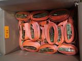 a cardboard box filled with orange hoses and hoses