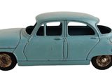 une petite voiture bleue posée sur une surface blanche
