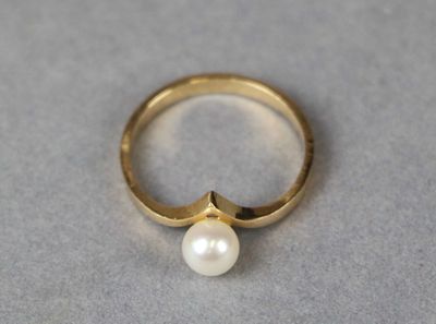 a close up of a gold ring with a pearl on it