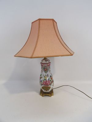 a lamp that is sitting on a table with a pink shade