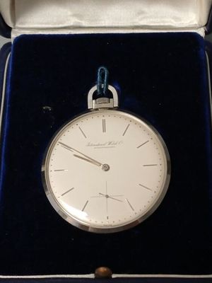 a silver pocket watch in a blue velvet case
