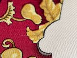 a close up of a red tie with a gold design on it