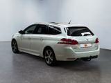 the rear end of a white car parked in a garage