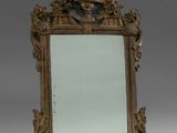 an antique mirror with a gold frame and a decorative decoration