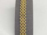 a close up of a bracelet with gold beads on it