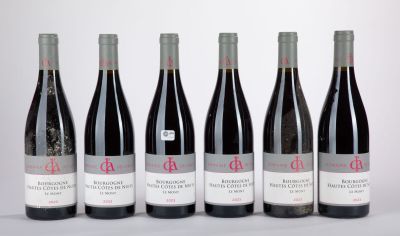 six bouteilles de vin sont alignées sur une table